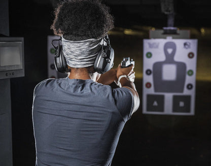 A woman practicing defensive shooting at the range. 